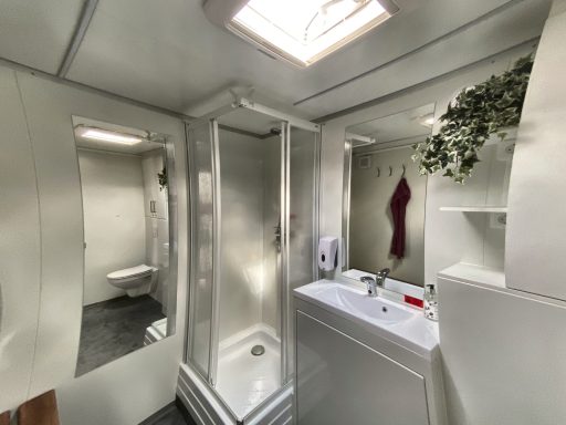 Mobiles Badezimmer innen – Dusche, Waschbecken und Spiegel im Badanhänger von TK-Montagebau